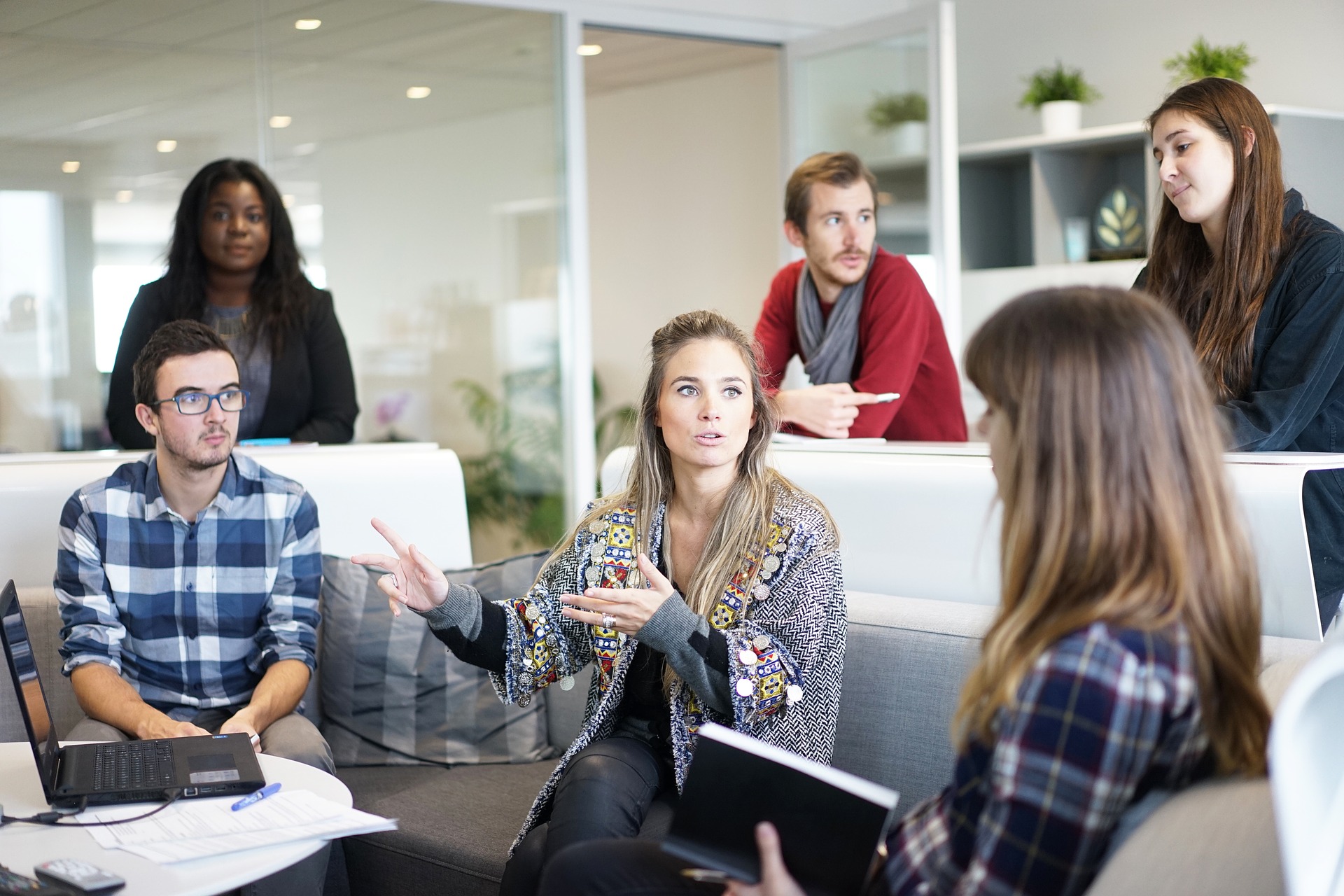 a woman speaking in a business meeting with a few people surrounding her